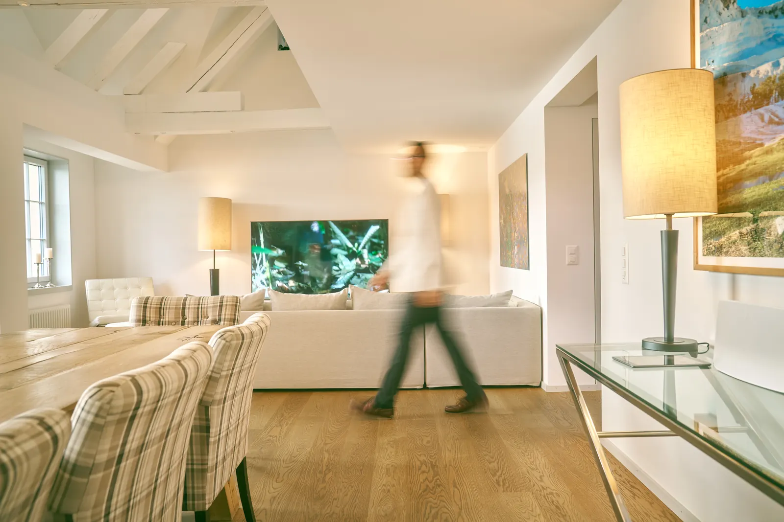 A person walks through an open-plan living area, blurred by motion